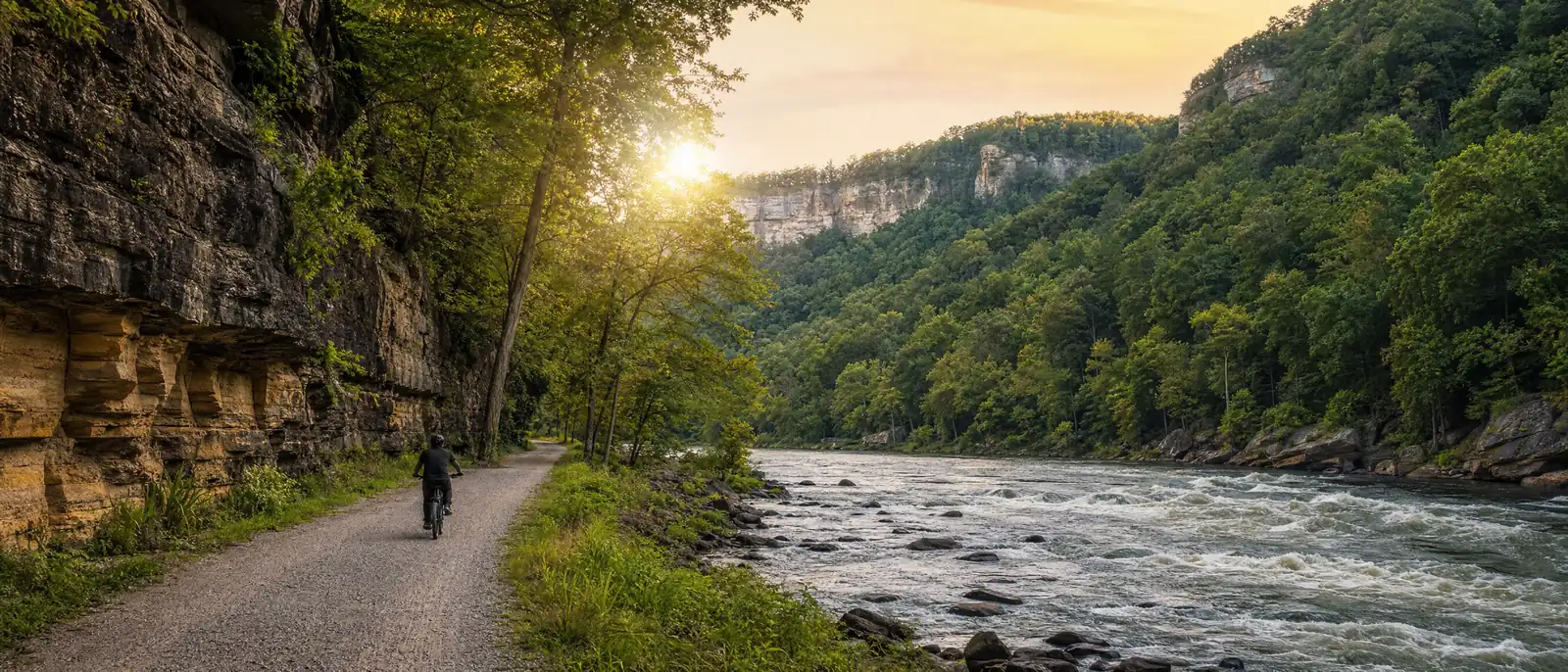 Illustration of an eBike rider on a rail-trail along a rushing river in a deep forested gorge with sandstone cliffs, in the style of the New River Gorge region, WV