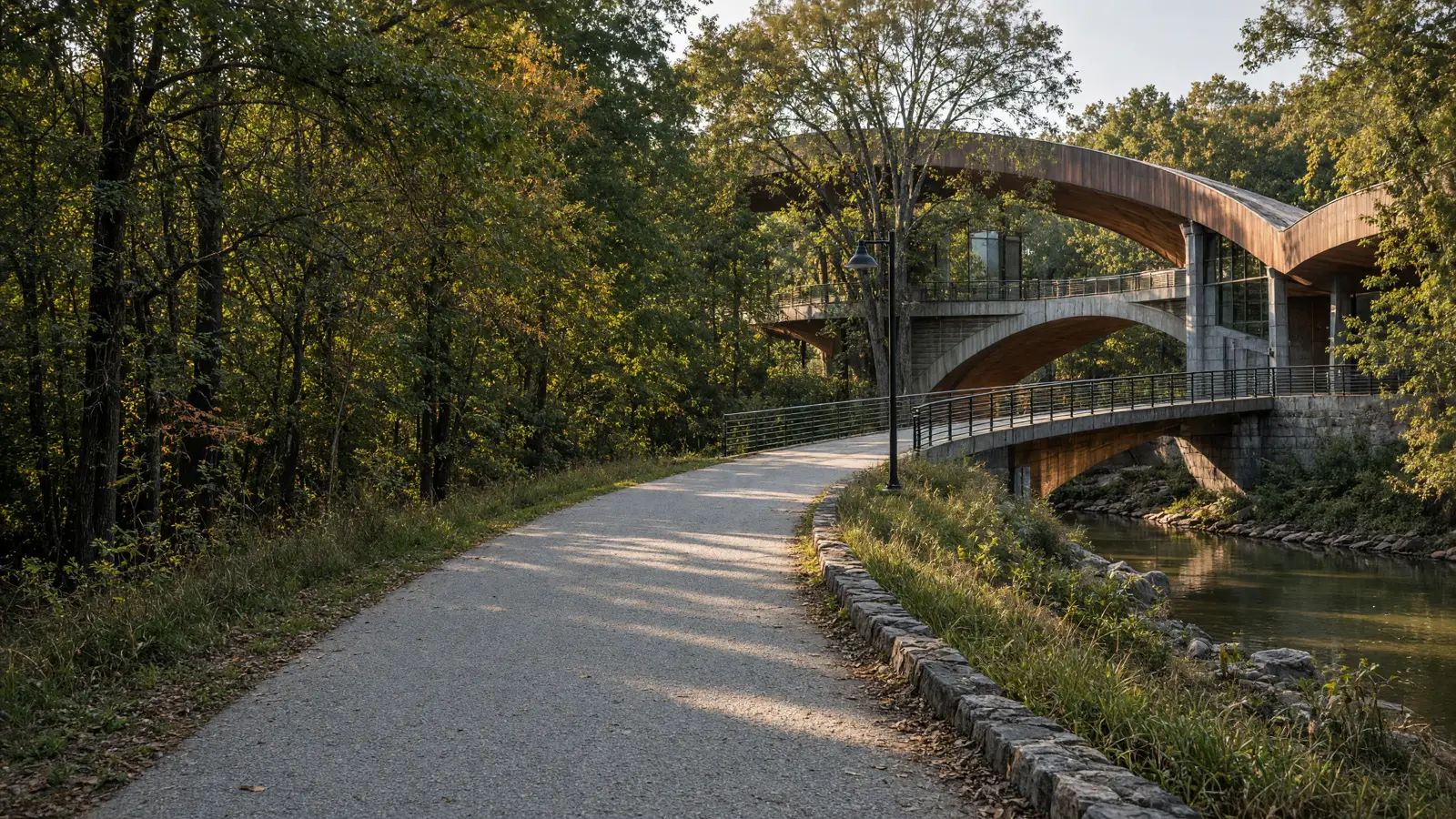 Empty Razorback Regional Greenway paved path beside an Ozark creek toward Crystal Bridges, Benton County, Arkansas