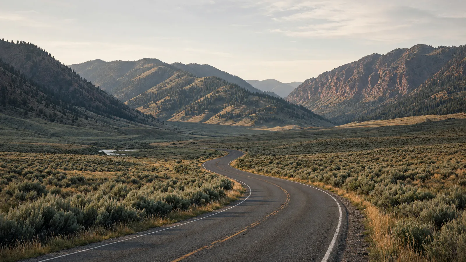 Empty Salmon River valley two-lane through sagebrush toward forested mountains near Salmon, Lemhi County, Idaho