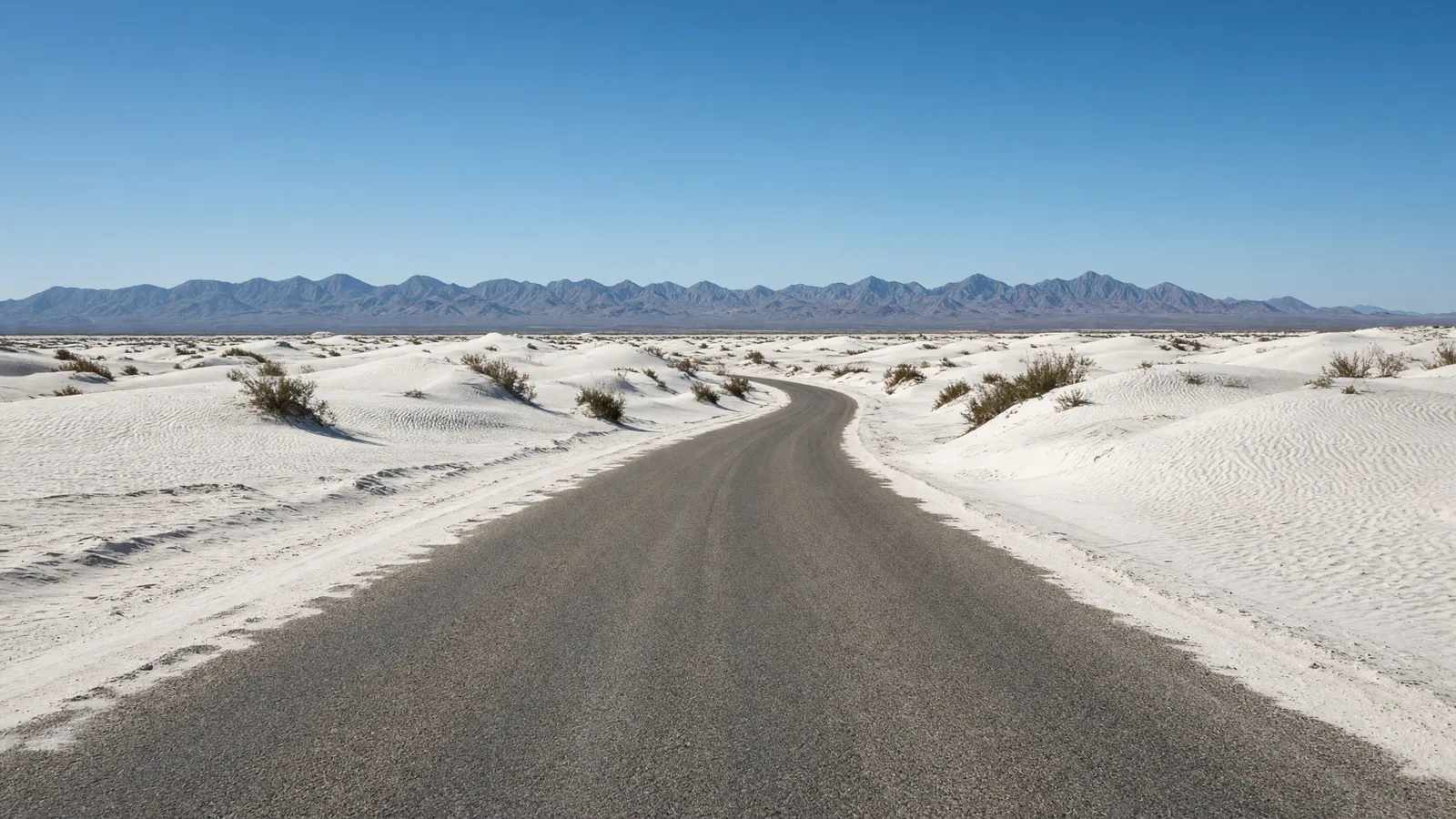 Empty White Sands gypsum dune road with white dunes and distant San Andres Mountains, Otero County, New Mexico