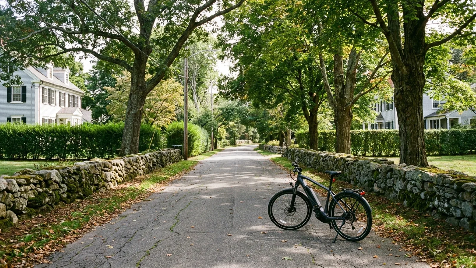 Electric bike at the roadside on a narrow tree-canopied back road with dry stone walls in coastal Connecticut